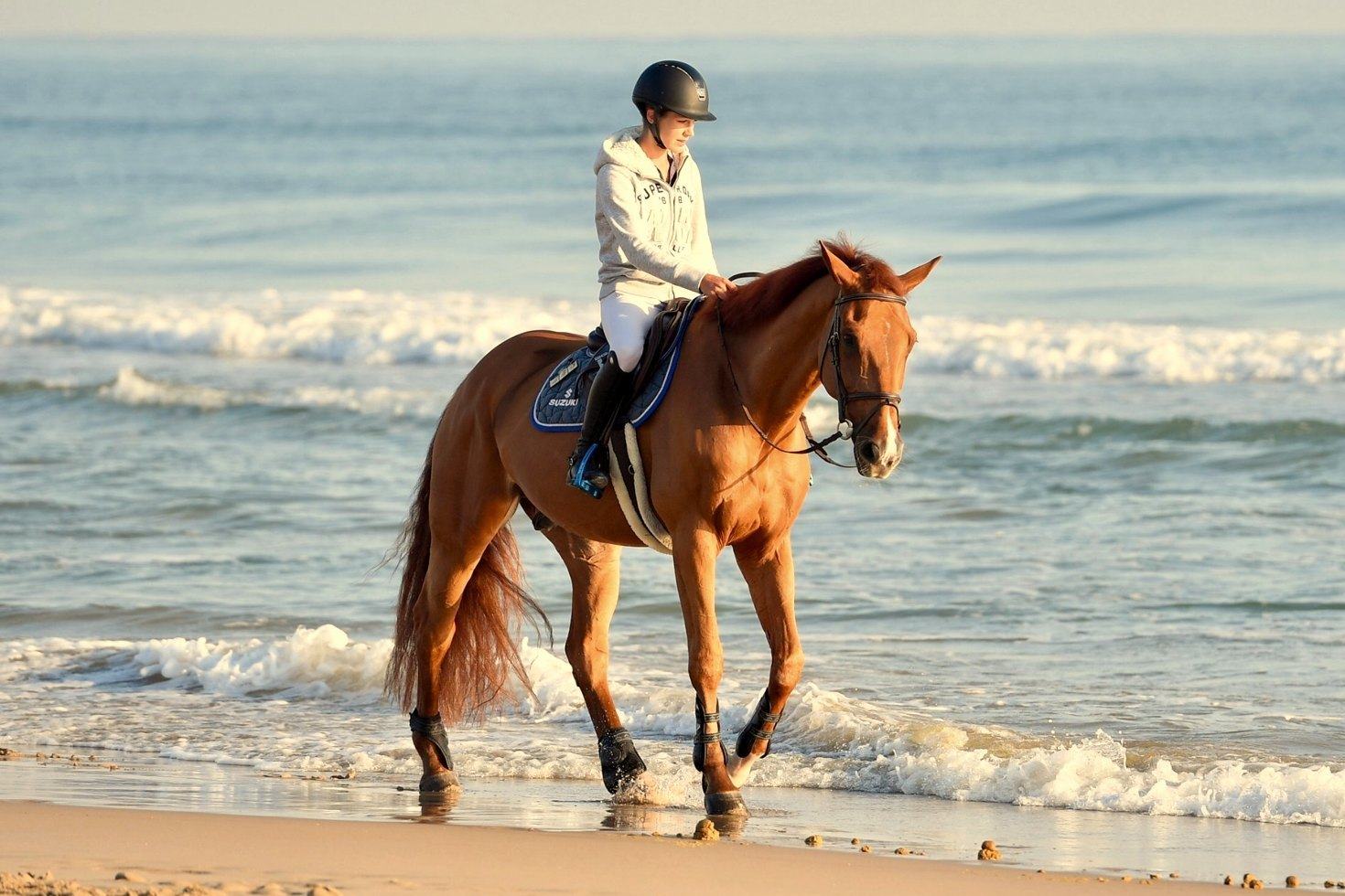 Diana paseando a caballo por la orilla de la playa