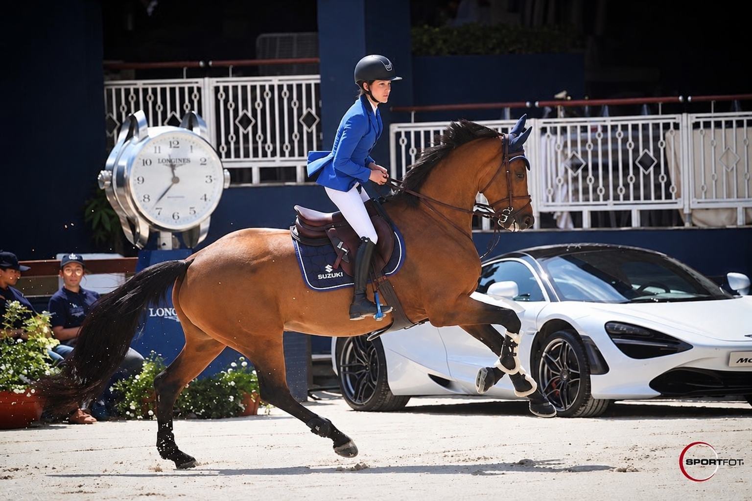 Diana de joven a galope con un caballo castaño en un concurso internacional